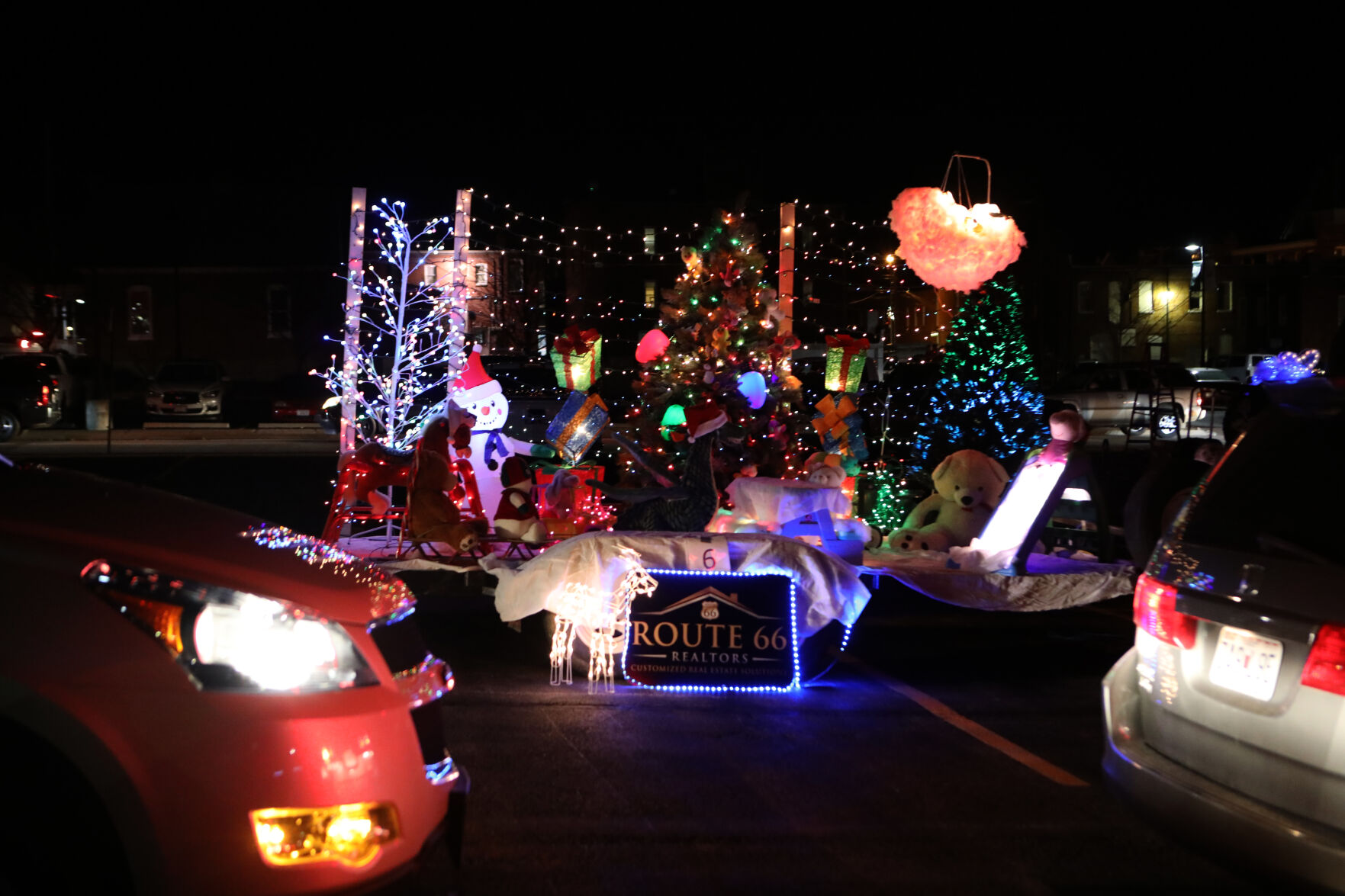 Cars drive past the Route 66 Realtors float